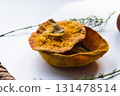 Dried pumpkin - container with a lid and a dried mandarin with a leaf, horsetail, and a spruce cone on a white background. Still life. 131478514