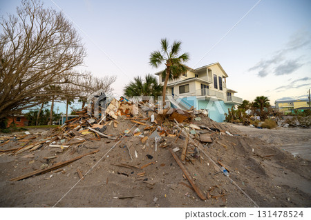 Rubbish and scrap disposed in heaps on street side after hurricane severely damaged houses in Florida home residential area. Consequences of natural disaster 131478524