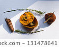 Dried pumpkin - container with a lid and a dried mandarin with a leaf, horsetail, and a spruce cone on a white background. Still life. 131478641