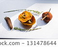 Dried pumpkin - container with a lid and a dried mandarin with a leaf, horsetail, and a spruce cone on a white background. Still life. 131478644
