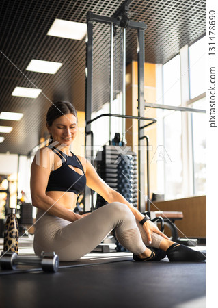 Fitness woman relaxing on mat use smartphone chatting at gym enjoy break 131478690