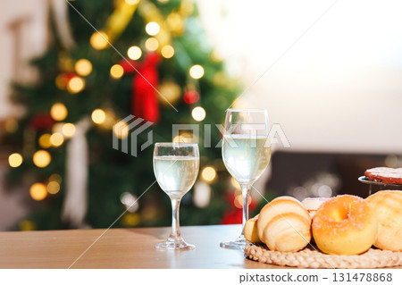 New Year Celebration. Sparkling drinks and pastries near a beautifully decorated Christmas tree. New Year Celebration. Sparkling drinks and pastries near a beautifully decorated Christmas tree. 131478868