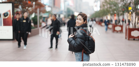 woman traveler visiting in Shanghai, China. Happy Female Tourist sightseeing in Nanjing road, shopping district of Shanghai. landmark and popular for tourism attractions. Travel and Vacation concept 131478890