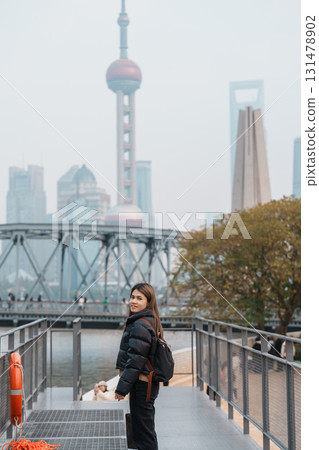 woman traveler visiting in Shanghai, China. Happy Female Tourist sightseeing Oriental Pearl Tower and Waibaidu Bridge view. landmark and popular for tourism attractions. Travel and vacation concept 131478902