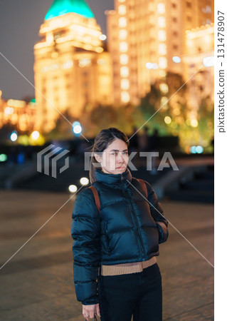 woman traveler visiting in Shanghai, China. Happy Female Tourist sightseeing Shanghai view in The Bund of Shanghai at night. landmark and popular for tourism attractions. Travel and Vacation concept 131478907