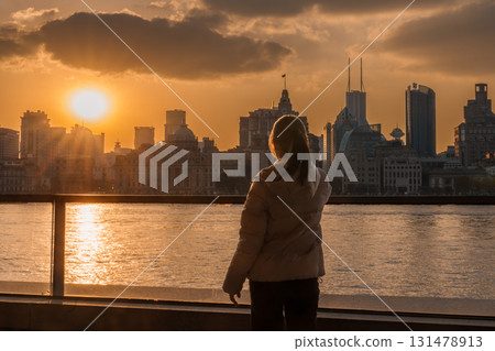woman traveler visiting in Shanghai, China. Happy Female Tourist sightseeing Shanghai view of the bund in Lujiazui at sunset. landmark and popular for tourism attractions. Travel and Vacation concept 131478913