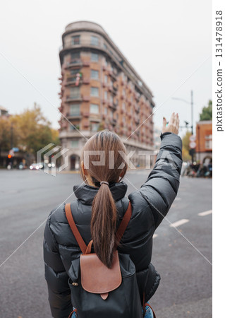 woman traveler visiting in Shanghai, China. Female Tourist with backpack sightseeing Wukang Mansion with Wukang Road and Middle Huaihai Road. landmark and popular for tourism attractions in Shanghai woman traveler visiting in Shanghai, China. Female Tourist with backpack sightseeing Wukang Mansion with Wukang Road and Middle Huaihai Road. landmark and popular for tourism attractions in Shanghai 131478918
