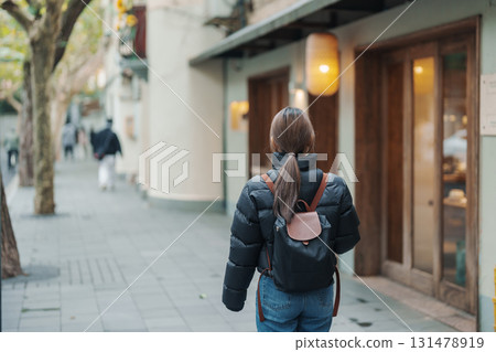 woman traveler visiting in Shanghai, China. Female Tourist with backpack sightseeing in Anfu road. landmark and popular for tourism attractions in Shanghai. Travel and vacation concept woman traveler visiting in Shanghai, China. Female Tourist with backpack sightseeing in Anfu road. landmark and popular for tourism attractions in Shanghai. Travel and vacation concept 131478919