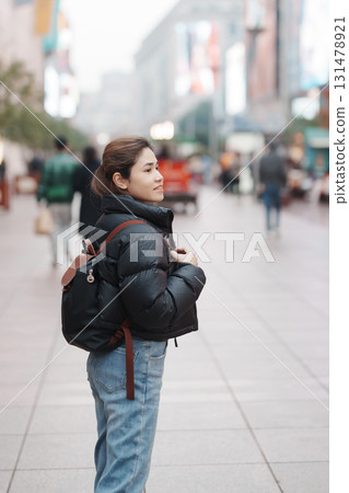woman traveler visiting in Shanghai, China. Happy Female Tourist sightseeing in Nanjing road, shopping district of Shanghai. landmark and popular for tourism attractions. Travel and Vacation concept 131478921