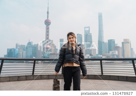 woman traveler visiting in Shanghai, China. Happy Female Tourist sightseeing Shanghai view of Lujiazui in The Bund of Shanghai. landmark and popular for tourism attractions. Vacation concept 131478927