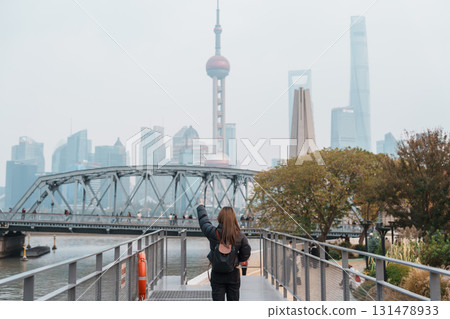 woman traveler visiting in Shanghai, China. Happy Female Tourist sightseeing Oriental Pearl Tower and Waibaidu Bridge view. landmark and popular for tourism attractions. Travel and vacation concept woman traveler visiting in Shanghai, China. Happy Female Tourist sightseeing Oriental Pearl Tower and Waibaidu Bridge view. landmark and popular for tourism attractions. Travel and vacation concept 131478933