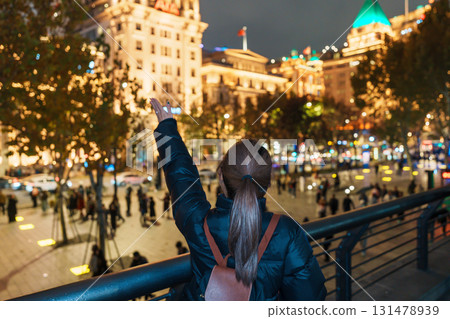 woman traveler visiting in Shanghai, China. Happy Female Tourist sightseeing Shanghai view in The Bund of Shanghai at night. landmark and popular for tourism attractions. Travel and Vacation concept woman traveler visiting in Shanghai, China. Happy Female Tourist sightseeing Shanghai view in The Bund of Shanghai at night. landmark and popular for tourism attractions. Travel and Vacation concept 131478939