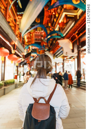 woman traveler visiting in Shanghai, China. Happy Female Tourist sightseeing and shopping in Yuyuan Old Street market at night. landmark and popular for tourism attractions. Travel and Vacation 131478948