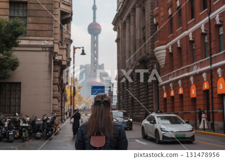 woman traveler visiting in Shanghai, China. Happy Female Tourist sightseeing Oriental Pearl Tower view in The Rock Bund of Shanghai. landmark and popular for tourism attractions. Travel and Vacation 131478956