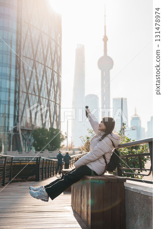 woman traveler visiting in Shanghai, China. Female Tourist with backpack sightseeing Shanghai view of Lujiazui in Hongkou Gang canal of Shanghai. landmark and popular for tourism attraction 131478974