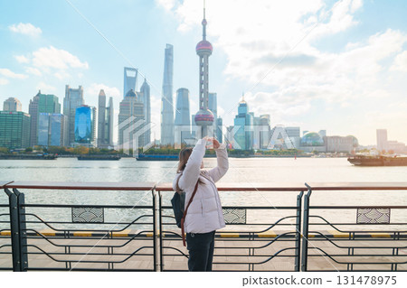 woman traveler visiting in Shanghai, China. Happy Female Tourist sightseeing Shanghai view of Lujiazui in The north Bund of Shanghai. landmark and popular for tourism attractions. Vacation concept woman traveler visiting in Shanghai, China. Happy Female Tourist sightseeing Shanghai view of Lujiazui in The north Bund of Shanghai. landmark and popular for tourism attractions. Vacation concept 131478975