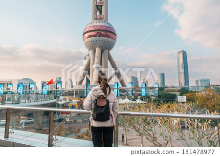 woman traveler visiting in Shanghai, China. Happy Female Tourist sightseeing Shanghai Oriental Pearl Tower view in Lujiazui. landmark and popular for tourism attractions. Travel and Vacation concept 131478977