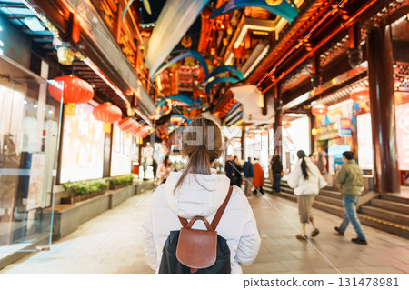 woman traveler visiting in Shanghai, China. Happy Female Tourist sightseeing and shopping in Yuyuan Old Street market at night. landmark and popular for tourism attractions. Travel and Vacation 131478981