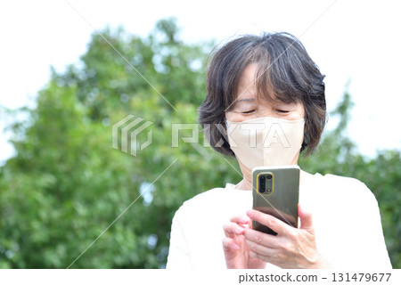 A woman operating a mobile phone 131479677