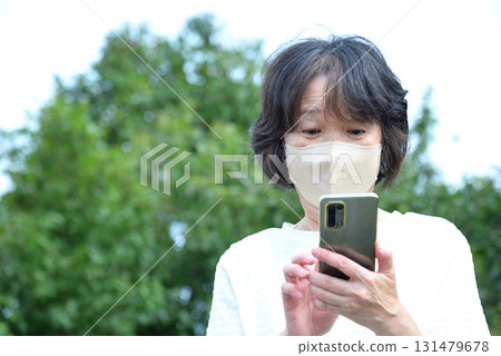 A woman operating a mobile phone 131479678