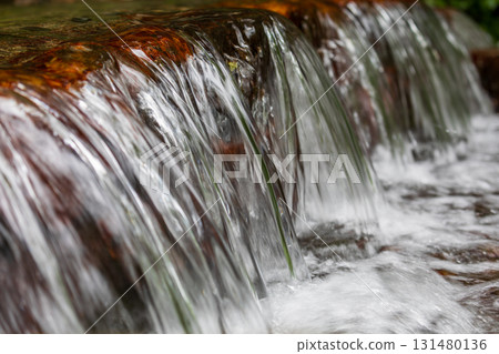 A silky waterfall in a mountain stream A silky waterfall in a mountain stream 131480136