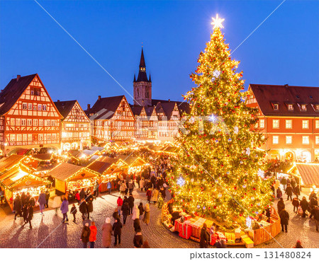 Christmas market and illuminated wooden stalls in a snowy landscape 131480824