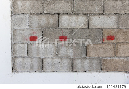 Worker is marking lebel for electrical outlets and wall switches location on new kitchen wall. Worker is marking lebel for electrical outlets and wall switches location on new kitchen wall. 131481179