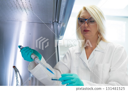 Scientist performing microbiological experiment, analyzing bacterial growth. Scientist performing microbiological experiment, analyzing bacterial growth. 131481525