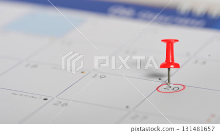 Red push pin marking the 20th on a calendar, symbolizing an important appointment or event reminder Red push pin marking the 20th on a calendar, symbolizing an important appointment or event reminder 131481657