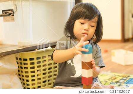Toddler girl stacking building blocks 131482067
