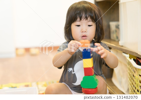 Toddler girl stacking building blocks 131482070