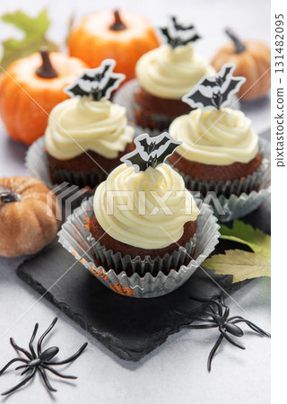 Halloween cupcakes with bat toppers and pumpkin decorations 131482095