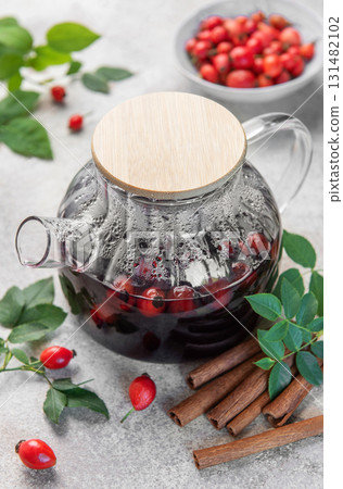 Rosehip tea brewing in glass teapot with cinnamon 131482102