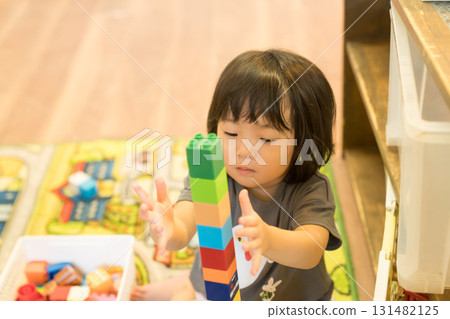 Toddler girl stacking building blocks 131482125