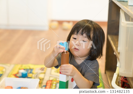 Toddler girl stacking building blocks Toddler girl stacking building blocks 131482135