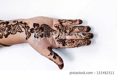 Picture of human hand being decorated with henna tattoo,Decorated Mehendi cone in Indian wedding ceremony 131482311