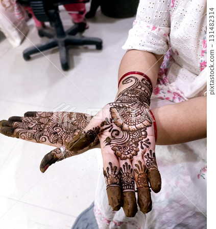 Picture of human hand being decorated with henna tattoo,Decorated Mehendi cone in Indian wedding ceremony Picture of human hand being decorated with henna tattoo,Decorated Mehendi cone in Indian wedding ceremony 131482314