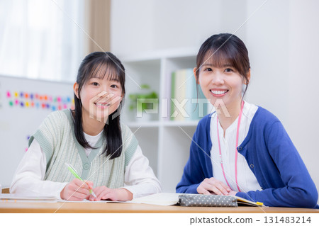 Female junior high school student studying with teacher at cram school Female junior high school student studying with teacher at cram school 131483214