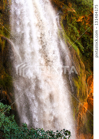 Scenic vertical waterfall surrounded by lush forest in Spain Scenic vertical waterfall surrounded by lush forest in Spain 131484175