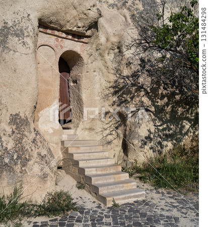 Ancient rock-cut cave church entrance with stone steps, Goreme, Cappadocia, Turkey Ancient rock-cut cave church entrance with stone steps, Goreme, Cappadocia, Turkey 131484298