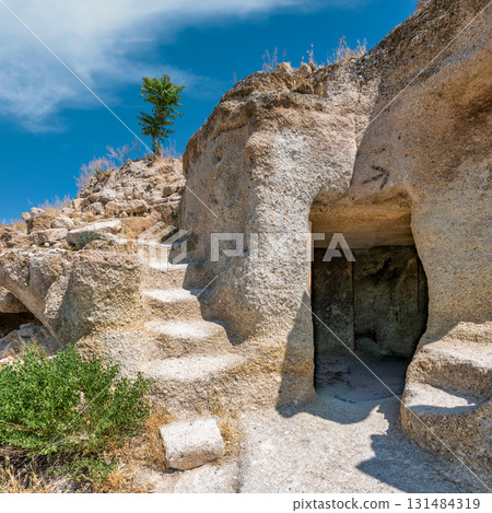 Rock-cut stairs and cave entrance on the path to St. John the Baptist Chapel, Gulsehir, Nevsehir, Turkey 131484319