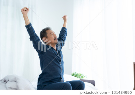Middle-aged man waking up in bedroom Middle-aged man waking up in bedroom 131484990
