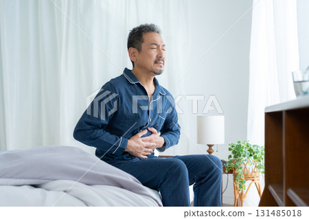 A middle-aged man who wakes up feeling unwell in the morning A middle-aged man who wakes up feeling unwell in the morning 131485018