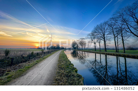A Serene and Beautiful Sunset Over a Tranquil and Idyllic Canal Landscape at Dusk A Serene and Beautiful Sunset Over a Tranquil and Idyllic Canal Landscape at Dusk 131486052