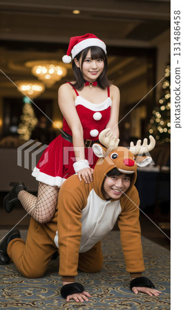 A woman dressed as Santa Claus and a man dressed as a reindeer 131486458