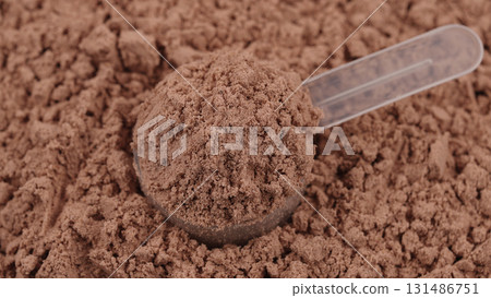 Scoop filled with chocolate protein powder. Close-up of sports nutrition supplement for fitness, healthy diet, muscle gain and workout recovery concept. Whey lean protein. Bodybuilding gym lifestyle 131486751