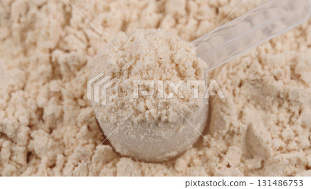 Scoop filled with vanilla protein powder. Macro close-up of sports nutrition supplement for fitness, healthy diet and muscle recovery concept. White protein, whey powder. Bodybuilding gym lifestyle 131486753