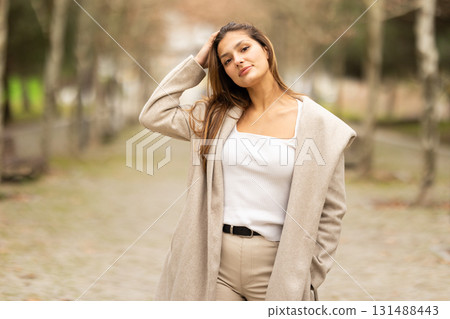 Young woman posing in casual beige outfit outdoors Young woman posing in casual beige outfit outdoors 131488443