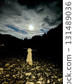 Large white dog sitting on the riverbank under the rising full moon | Outdoor camping on a moonlit night 131489036