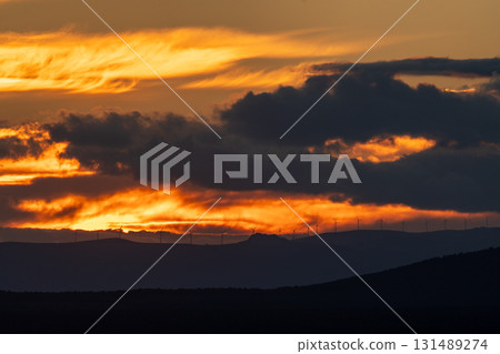 Dramatic Sunset with Wind Turbines on Horizon 131489274